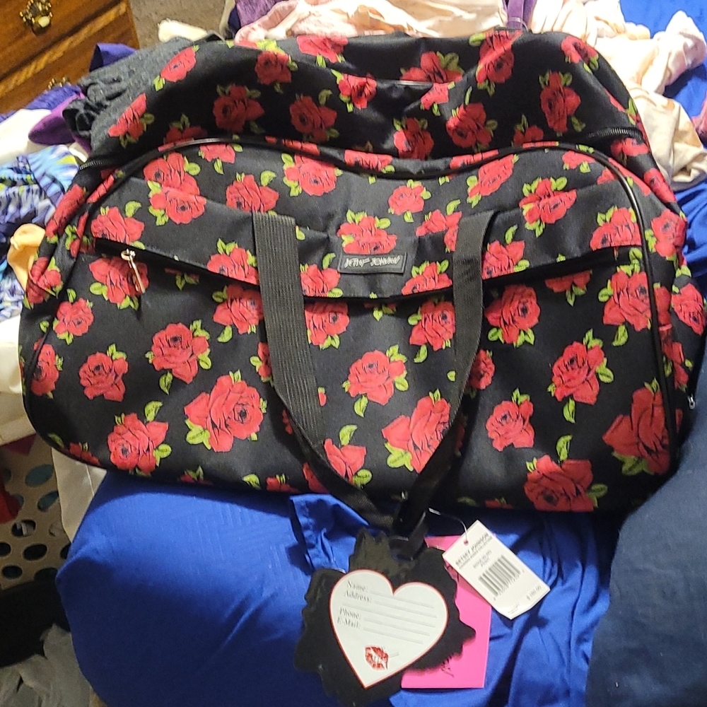 Betsy Johnson rolling luggage with luggage tag.